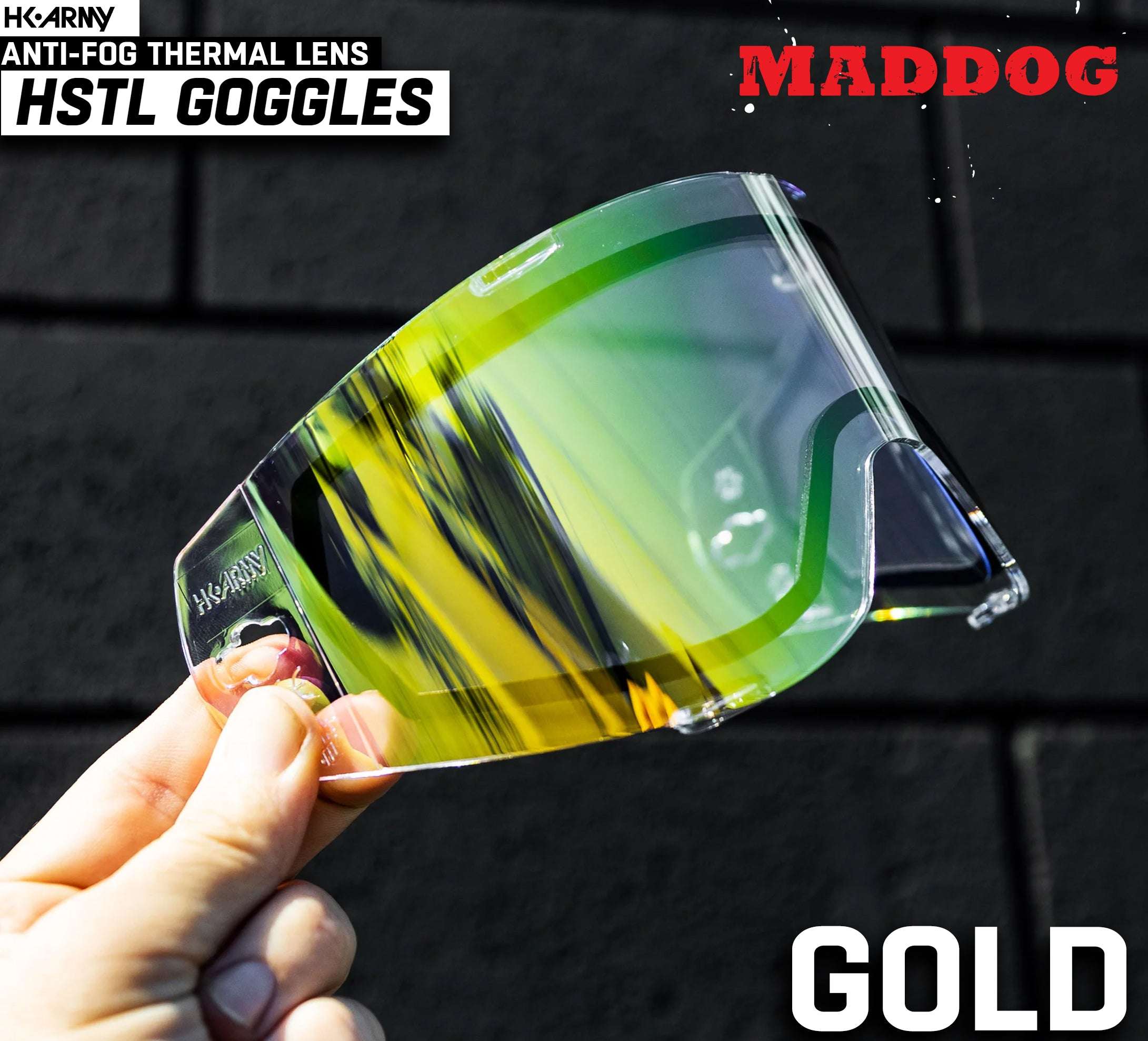 Maddog HK Army HSTL Goggle gold anti-fog thermal replacement lens held against dark background